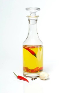 Bottle with chili oil, ingredients oil, chili peppers, garlic, peppercorns, piri-piri, pepperoni,
