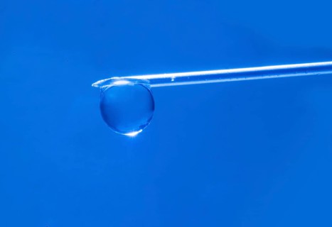 Macro image Covid vaccine, a drop of Moderna vaccine hangs on a vaccine needle
