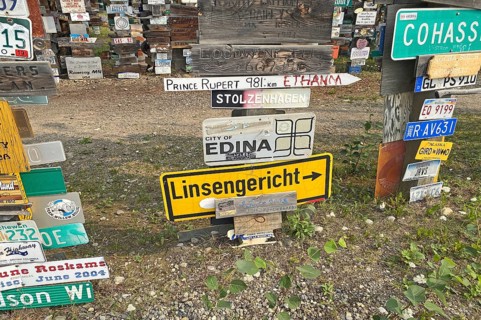 Place and traffic signs in a forest of signs, Linsengericht in Hesse, Watson Lake, Yukon Territory,
