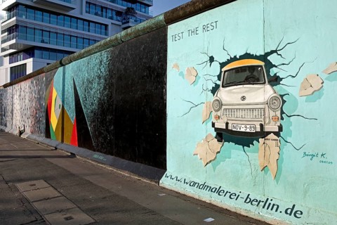 Mural on remnant of the Berlin Wall with the cardiac stress test (Test The Rest), Trabi durchbricht