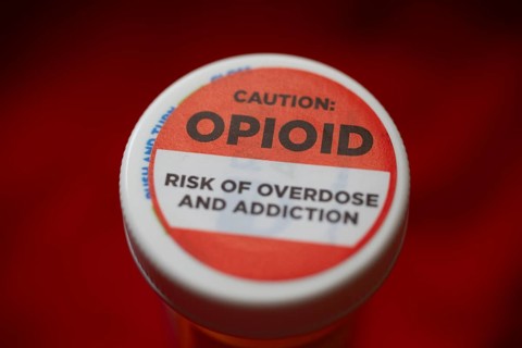 A label on a bottle of hydrocodone-acetamin opioid prescription pills warns against the danger of