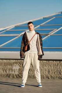 Urban fashion. Young man in loose clothes posing on the street
