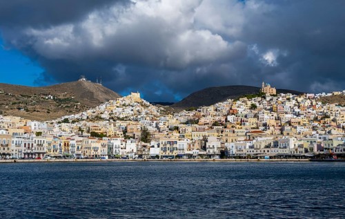 View of the town of Ermoupoli with pastel-coloured houses and sea, on the hill Anastasi Church or