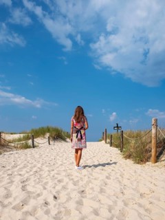 Woman in colourful dress on empty beach, Slovincian National Park, Slowinski Park Narodowy, Poland,