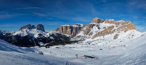 Panorama of a ski resort piste with people skiing in Dolomites in Italy. Ski area Belvedere.