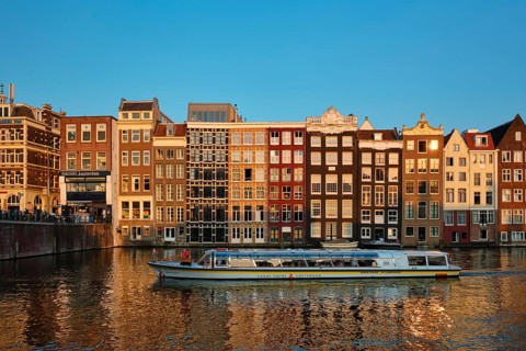 AMSTERDAM, NETHERLANDS, MAY 20, 2018: Canal cruise tourist boat in Amsterdam at Damrak canal and