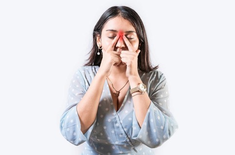 Girl with nasal bridge headache. Sinus pain concept. Young woman with pain touching nose. Person