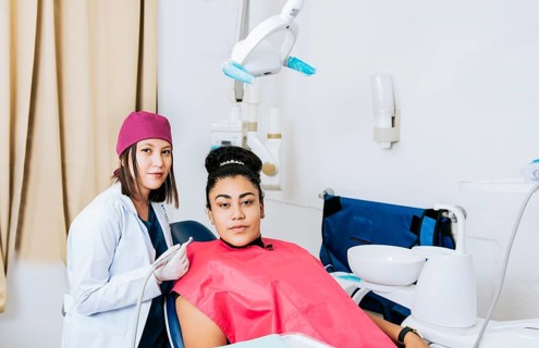 Portrait of young dentist with female patient in medical office, Female dentist with female patient