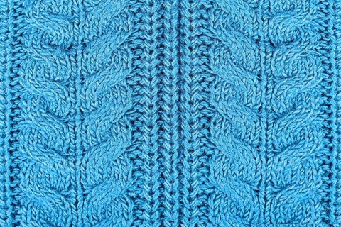 Close up of knitted pattern on blue wool pullover