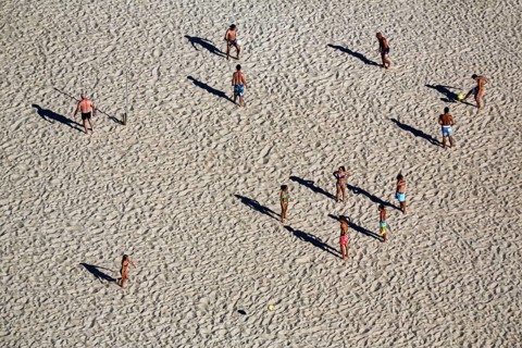 Beach volleyball on the beach of Nazaré, players cast long shadows, view from above, Portugal,