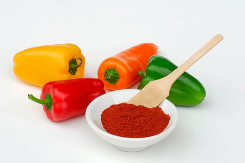 Orange, green, yellow and red peppers and paprika powder, sweet pepper