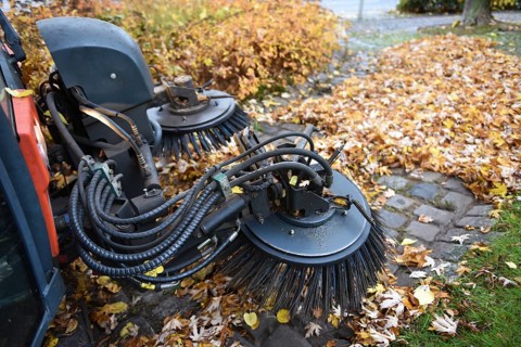 Sweeper sweeping wilted leaves in autumn, Vellmar, Hesse, Germany, Europe