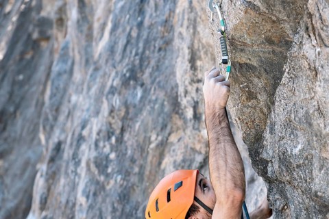 Close-up from above, rock climbing using outdoor safety harness and helmet