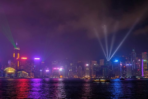 Hong Kong skyline cityscape downtown skyscrapers over Victoria Harbour in the evening illuminated