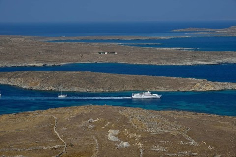 View over the island of Delos with an excursion boat, Cyclades, Greece, Europe
