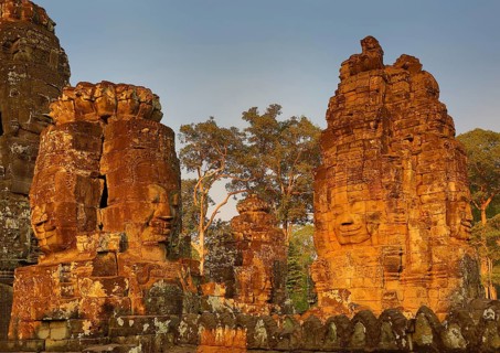 Giant stone faces at Bayon Temple at sunset, Angkor Wat, Cambodia, Asia