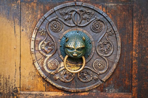 Old brass door knocker on wooden door