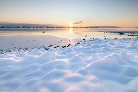 The wintery snow-covered lake with setting sun and peaceful atmosphere, Seegarten, Allensbach, Lake