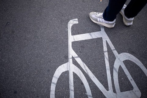 Close-up, shoes, sneakers, pedestrian standing on cycle path, marking, labelling, pictogram,