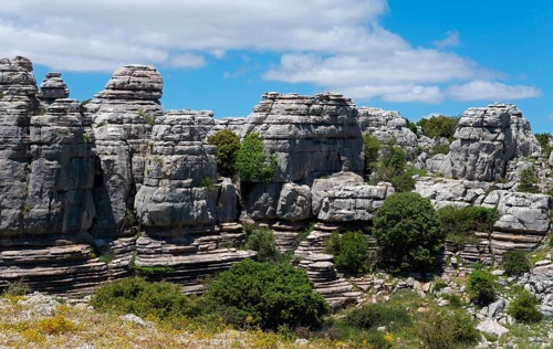 Massive rock formations with trees and blue sky in a wooded natural landscape, Karst Mountains,