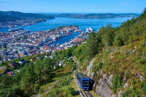Panoramic view of Bergen with harbour on a clear day, cable car ascending the wooded mountain,
