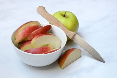Apple and apple slices in peel, sliced apple with knife