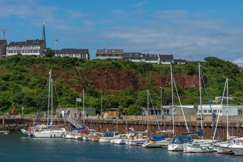 Sailing yachts in the north-east harbour, Buntsandstein cliff, Helgoländer Oberland with church