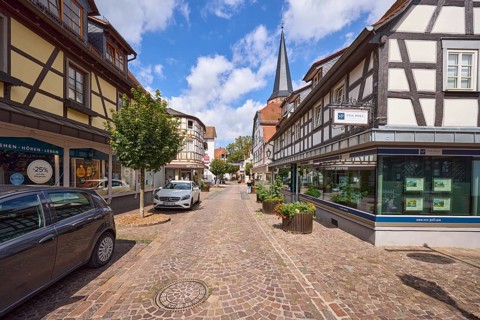 Braunstraße with half-timbered houses, Protestant town church, trees and planters in Michelstadt,