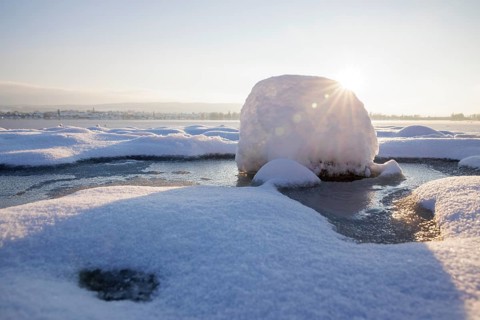 A snow-covered block of ice on a frozen body of water at sunrise, Seegarten, Allensbach, Lake