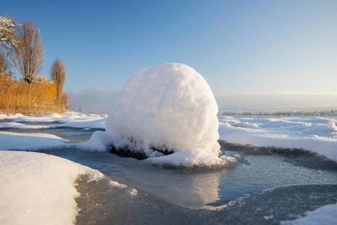 Snow globe on the ice of a frozen lake, Seegarten, Allensbach, Lake Constance, Baden-Württemberg,