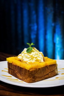 Exotic tropical fusion french toast dessert with mango and whipped cream