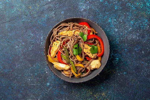 Japanese dish buckwheat soba noodles with chicken and vegetables carrot, bell pepper and green