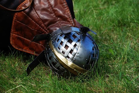 Iron helmet of knight on green grass