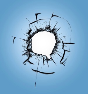 Bullet holes in the window against the blue sky. Consequences of shelling and cracks on the glass