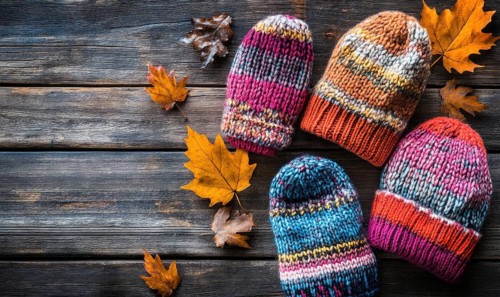 Vibrant knitted hats on a rustic wooden background AI generated