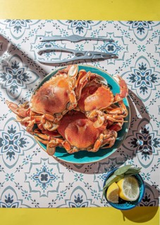Food Photography, Cooked crab on blue plate, lemons, rose wine on table, sunlight immitation
