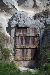 Old iron door set in a cliff face, Dunedin, South Island, New Zealand, Oceania