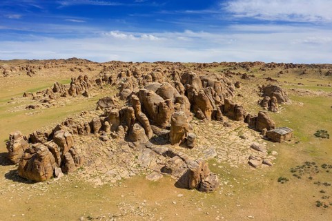Aerial view at rock formations and stacked stones on granite hilltops. Baga Gazriin Chuluu, Gobi