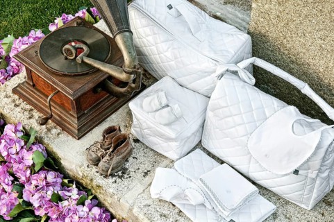 Vintage baby clothes and gramophone in garden
