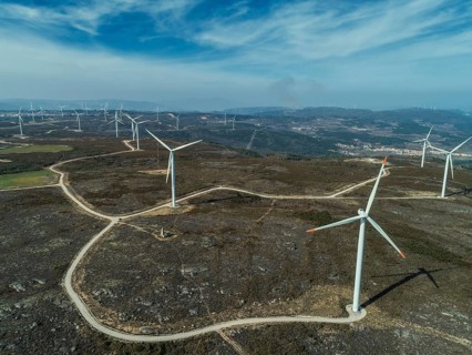 Aerial view of lot of windmills or wind turbine on wind farm in rotation to generate electricity