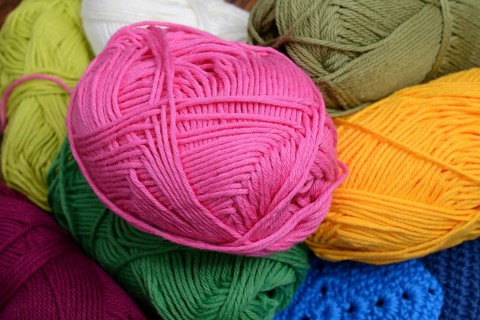 Colorful skeins of wool, pink yellow and green