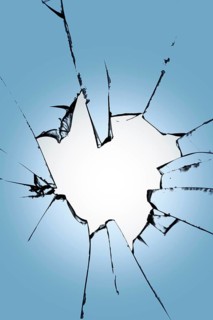Pieces of broken glass with a hole in the center on a blue background. Texture of cracks on the