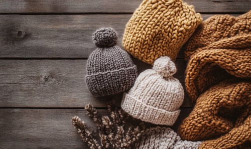 Vibrant knitted hats on a rustic wooden background AI generated