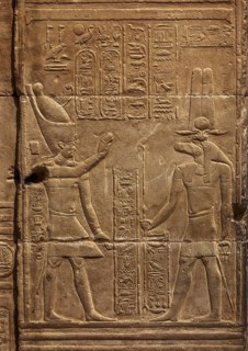 Hieroglyphic carvings of Sebek god and pharaoh on the walls of an ancient egyptian temple