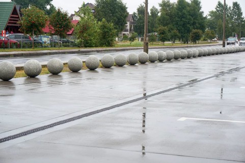 Stone balls as a design course in the landscape of the city, wet road, rainy day
