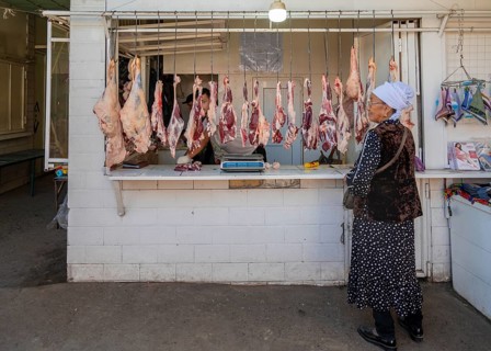 Woman at the market stall for meat products, Uzgen Bazaar, Ösgön, Osh region, Kyrgyzstan, Asia
