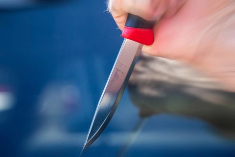 Symbolic image of a knife attack: close-up of a knife in a man's hand