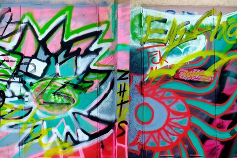 Colourful graffiti artworks cover two walls, showing abstract shapes and tags in an urban