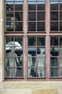 From behind sculptures, male figures, cast collection in the window from the outside, plaster