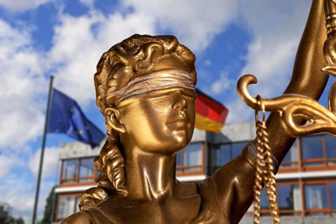 Symbolic image: Close-up of a Justitia, in the background the Federal Constitutional Court in